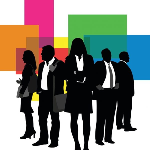 A vector silhouette illustration of a team of buisiness professionals lead by a stong business woman in the center.  They stand in fronf of a colouful block pattern.